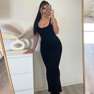 Selfie miroir montrant la coupe d'une robe maxi noire en maille côtelée à bretelles
