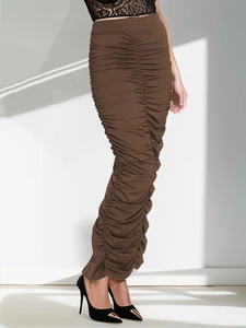 Detail view of the elegant ruched texture on a dark brown high-waisted midi skirt