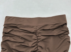 Detail of dark brown high waist skirt featuring pleated texture and shirring design