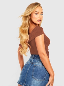 Detailed close-up of brown textured off-shoulder bodysuit paired with denim skirt