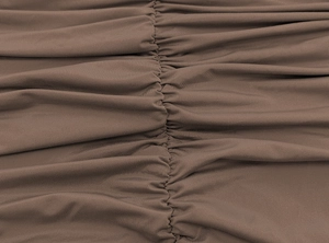 Close-up of brown ribbed fabric featuring central ruched detailing and neat stitching