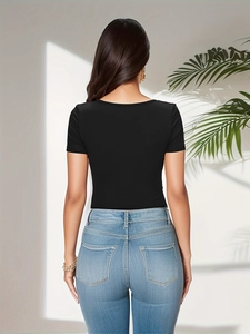 Rear view detail of slim fit black ribbed bodysuit paired with light blue denim jeans