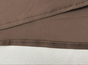 Detail of high waist brown skirt showing fine knit texture and double needle stitching