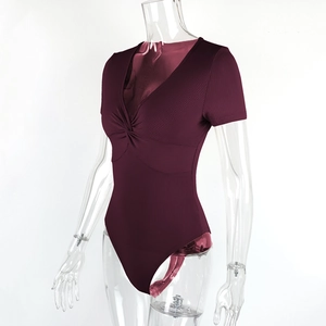 Macro detail of wine red ribbed fabric and stylish twist knot on the V-neck bodysuit