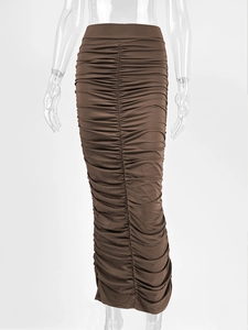 Detail of ruched center seam and elastic fabric on a brown high-waist midi skirt