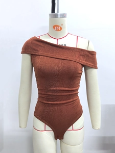 Detail of caramel off-shoulder ribbed bodysuit showing textured metallic knit fabric