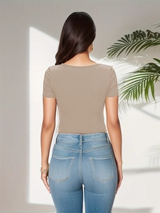 Slim fit beige ribbed bodysuit for women styled with light blue jeans in bright natural light