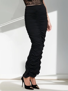 Detail of ruched high-waist black midi skirt with elegant rear slit and slim fit fabric