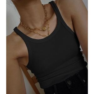 Close-up of black ribbed cotton U-neck tank top with layered gold pendant necklace