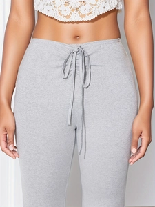 Detail of grey pleated lounge pants with adjustable drawstring waist and ribbed texture
