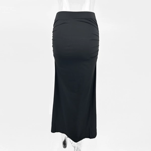 Detail view of the ruched side texture and slim fit black maxi skirt fabric