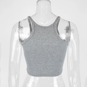 Close-up of gray ribbed knit crop top featuring racerback design and elastic fabric