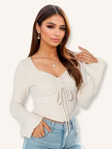 Detail view of beige ribbed long sleeve crop top with drawstring V-neck and flare sleeves