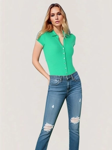 Detail of bright green short sleeve polo bodysuit with buttons and distressed denim jeans