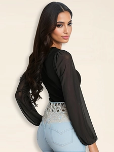 Dettaglio di ricami e paillettes argentate sulla vita dei jeans stile boho