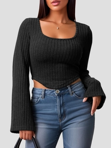 Detail view of black ribbed knit top with U-neckline and irregular V-cut hemline
