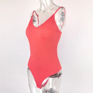 Détail macro du tricot côtelé corail et décolleté en V profond du body chic