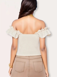 Close-up of the ruffled off-shoulder neckline and ribbed knit texture on the beige top