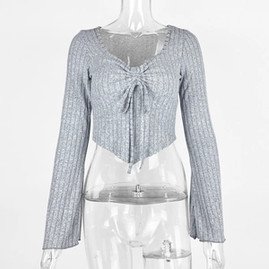 Detail of ribbed knit grey V-neck crop top with drawstring ties and flared long sleeves