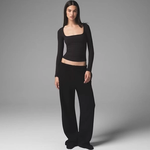 Dettaglio top aderente a maniche lunghe con scollo quadrato e pantaloni a gamba larga
