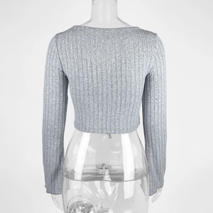 Rear view of grey ribbed knit long sleeve crop top with a classic round neckline
