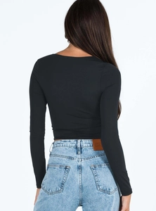 Dettaglio della vista posteriore della maglia nera aderente a maniche lunghe e jeans blu