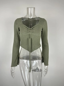 Detail of olive green ribbed knit texture with V-neckline and drawstring ruched front