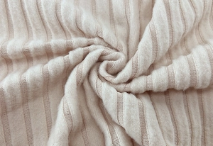 Close-up of beige ribbed knit fabric texture with soft plush feel and vertical stripes