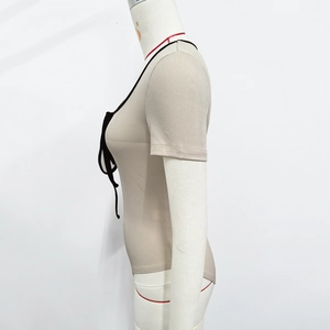 Détail du body en maille côtelée beige avec laçage noir au décolleté en U et bord contrasté