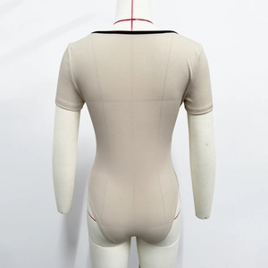 Détail du body beige présentant une texture en maille et une bordure noire au col