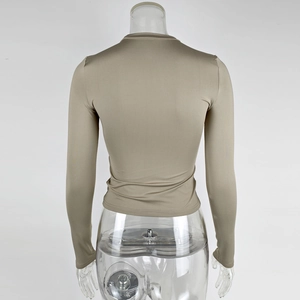 Detail of slim fit long sleeve top showing tight back tailoring and smooth beige fabric