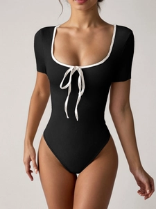Détail de la texture côtelée et du liseré blanc sur un bodysuit noir chic