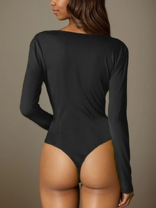 Rear view of sleek black long-sleeve bodysuit featuring a minimalist T-back design