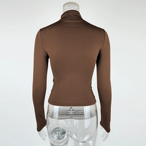 Detail view of the back side of a slim fit brown turtleneck long sleeve shirt on a mannequin