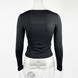 Dettaglio del retro di un top nero aderente a maniche lunghe con scollo quadrato e tessuto elastico