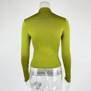 Rear view of grass green slim fit turtleneck long sleeve top on a transparent mannequin