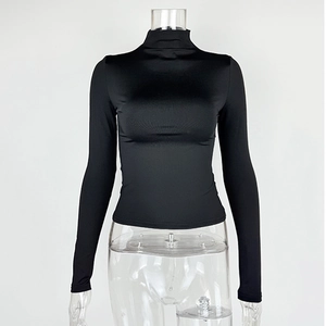 Detailed view of black slim-fit mock neck top with smooth elastic fabric and neat seams