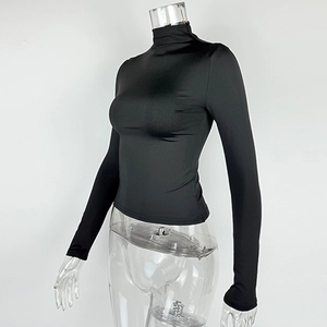 Detail of slim fit black turtleneck top with smooth elastic knit texture on mannequin