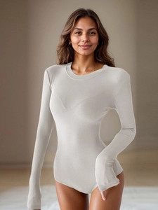 Close-up of the breathable ribbed knit fabric and slim-fit crewneck of the beige bodysuit