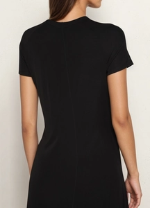 Detail of minimalist vertical back seam on a slim-fit black short-sleeve dress