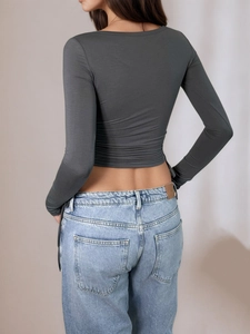 Back view of slim fit dark grey long sleeve crop top with light blue washed jeans