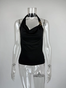 Detail of black halter top with elegant draped collar and golden metal ring decor