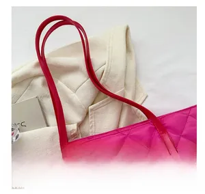 Detail of rose red quilted tote bag with long shoulder straps and diamond stitching