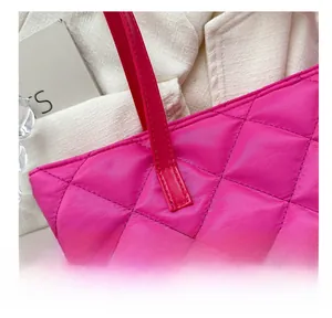 Detail of rose red quilted tote bag with diamond pattern stitching and sturdy handles