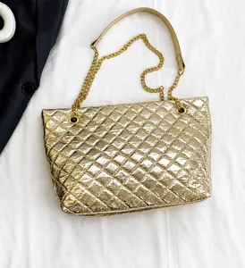 Close-up of golden quilted tote bag with diamond stitching and chain strap detail