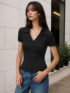 Detail of a slim fit black ribbed polo t-shirt with V-neck and collar on a model