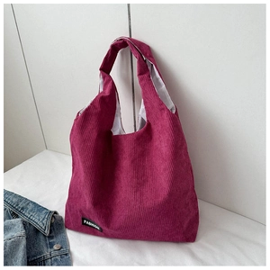 Détail du sac cabas en velours côtelé rose avec texture striée et étiquette de mode