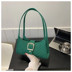 Dettaglio borsa baguette in feltro verde con cuciture diagonali e fibbia in oro grande