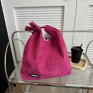Grand sac cabas en velours côtelé rose avec étiquette mode sur étagère design