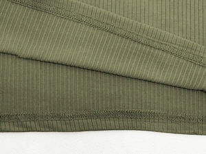 Close-up of army green ribbed knit fabric showing detailed stitching and vertical texture